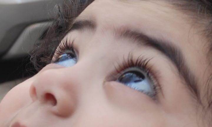 la bambina con occhi grandi e le ciglia lunghe guarda in alto